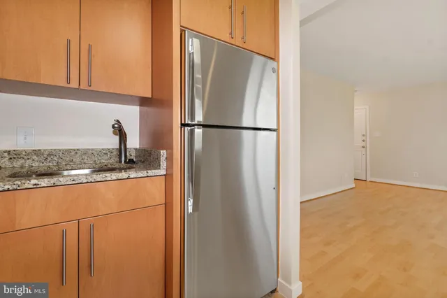 a kitchen with granite countertop a refrigerator and a sink