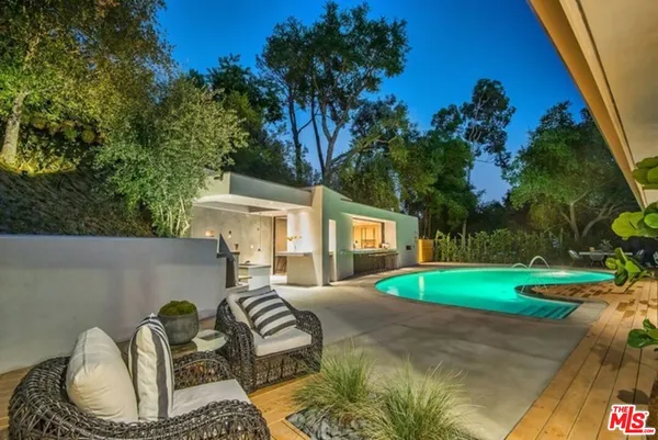 a backyard of a house with barbeque oven table and chairs