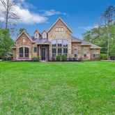 a front view of a house with a yard deck and green space