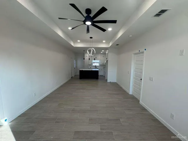 en empty room with wooden floor and ceiling fan