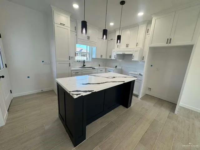 a kitchen with a sink a stove a refrigerator and white cabinets
