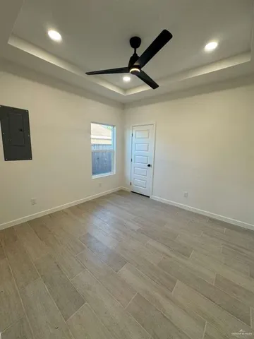 an empty room with ceiling fan and windows