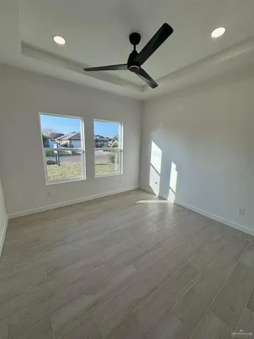 an empty room with windows and fan view