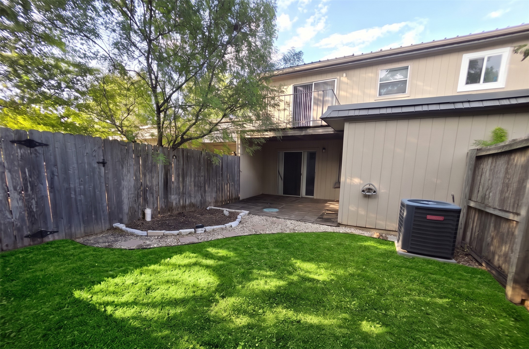 703 Castle Ridge Road, Unit B Austin, TX 78746 - Photo 18 of 18 A fenced lawn area provides private outdoor space adjacent to the rear patio and balcony.