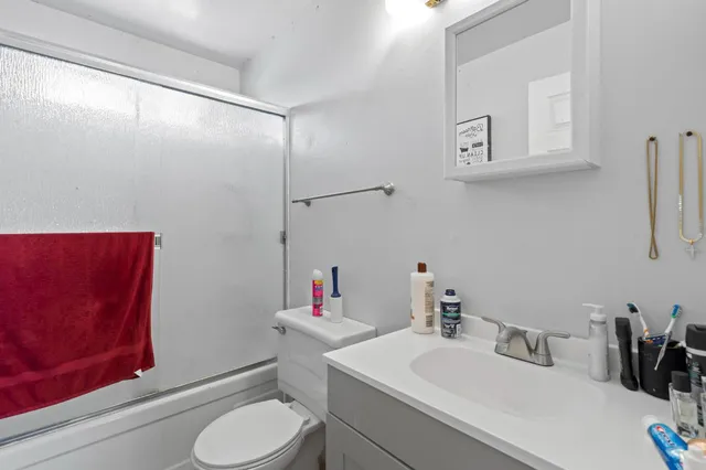 a bathroom with a sink vanity mirror and toilet