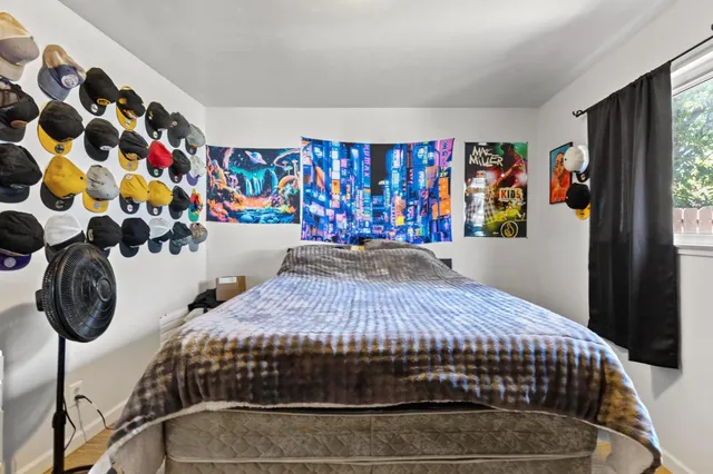 a bedroom with a bed and painting on the wall