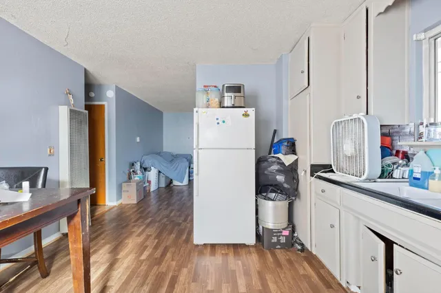 a kitchen with stainless steel appliances a refrigerator sink and wooden floor