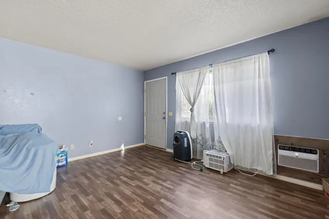 an empty room with wooden floor and a window