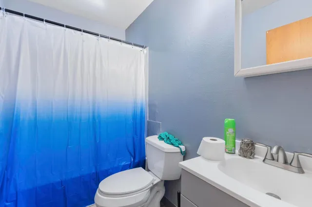 a bathroom with a sink a toilet and a window