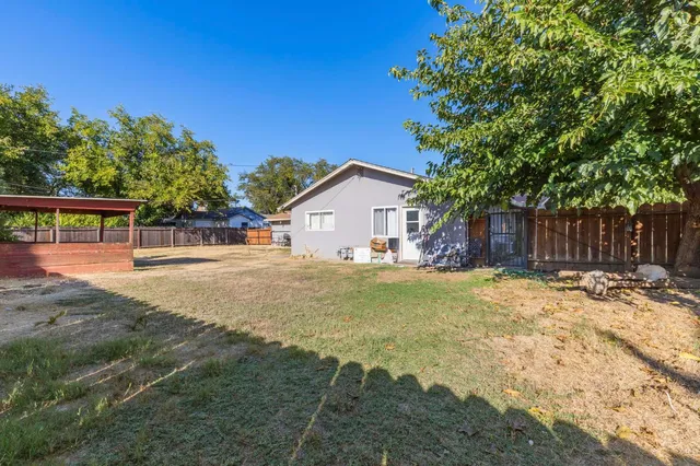 a view of house with backyard space and tree