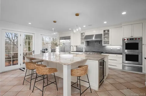 a kitchen with stainless steel appliances kitchen island granite countertop a stove a sink a dining table and chairs