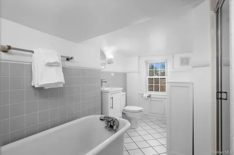 a bathroom with a granite countertop toilet a sink a mirror and a bathtub