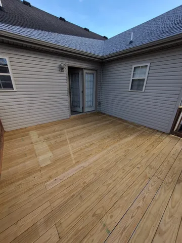 a view of balcony with wooden floor and fence