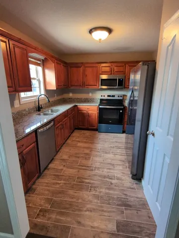 a kitchen with stainless steel appliances granite countertop a sink dishwasher stove and cabinets