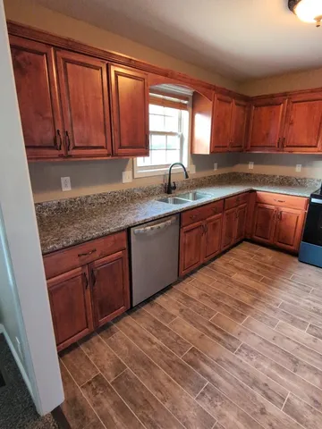 a kitchen with stainless steel appliances granite countertop a stove a sink dishwasher and a microwave oven with cabinets