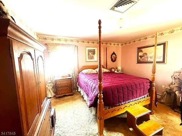 a bedroom with a bed dresser and a window