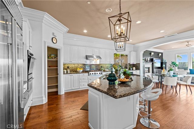 a kitchen with stainless steel appliances granite countertop a stove refrigerator and dining table