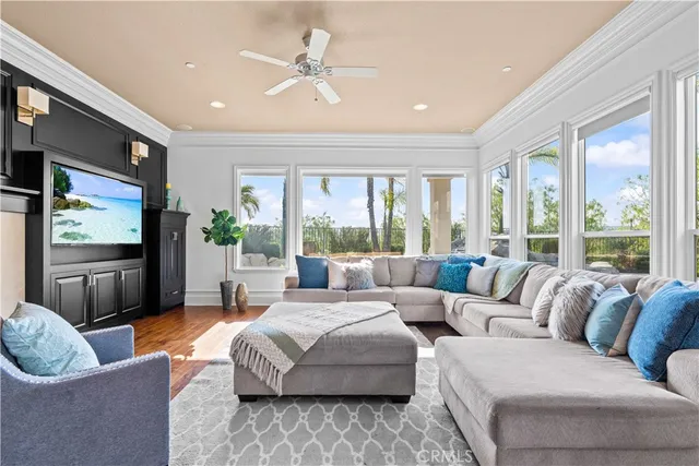 a living room with furniture ceiling fan and a flat screen tv