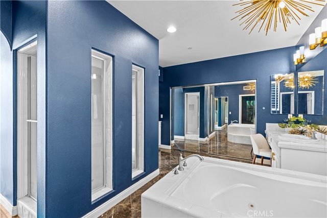 a bathroom with a tub sink and mirror