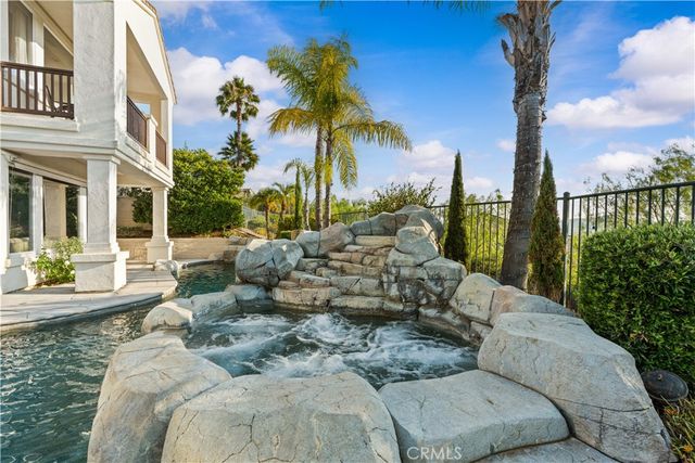 a view of a backyard with couches under an umbrella