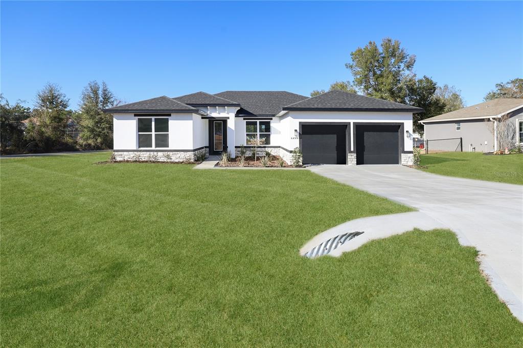 6499 Southwest 117th Street Ocala, FL 34476 - Photo 1 of 1 a front view of a house with a garden and yard