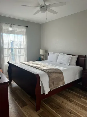 a bedroom with a bed and wooden floor