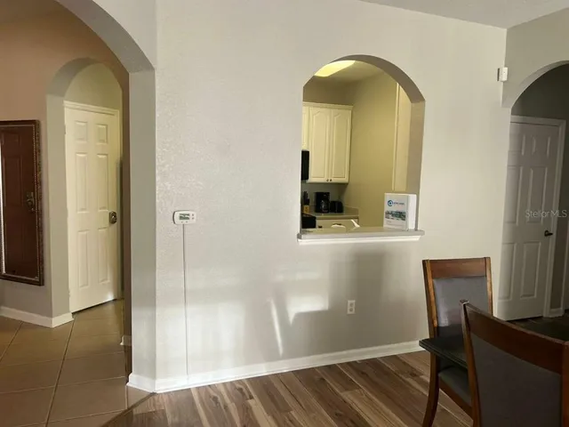 a view of a hallway with wooden floor and a livingroom