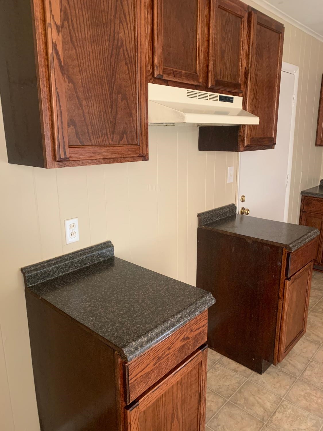 53 West Rollins Road Memphis, TN 38109 - Photo 13 of 16 a kitchen with granite countertop a sink dishwasher a stove and a microwave oven with cabinets