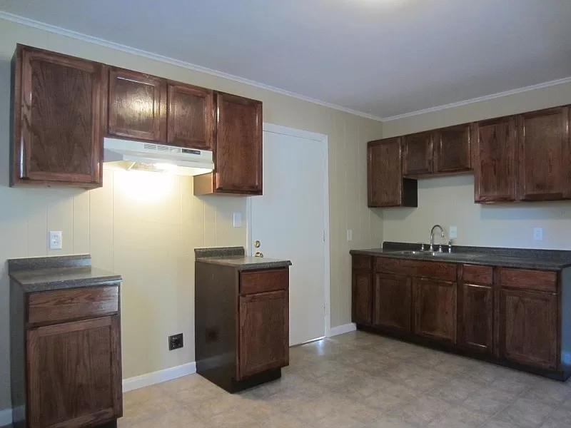 53 West Rollins Road Memphis, TN 38109 - Photo 3 of 16 a kitchen with stainless steel appliances granite countertop wooden cabinets a sink and a stove
