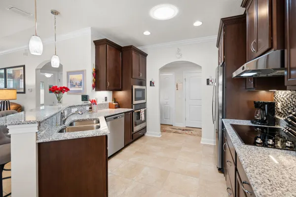 a kitchen with granite countertop a sink stainless steel appliances and cabinets