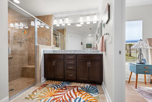 a spacious bathroom with a granite countertop sink a mirror and a shower