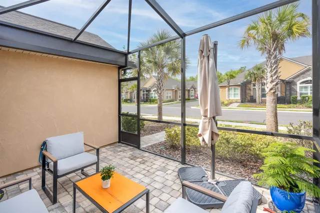 a view of a porch with furniture and floor to ceiling window