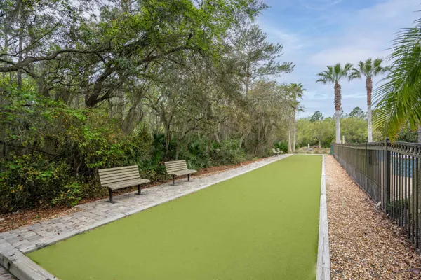 a view of a swimming pool with a bench and trees around