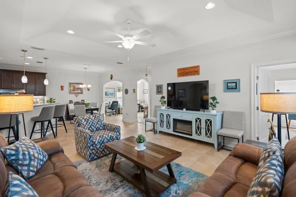 a living room with furniture a flat screen tv and kitchen view