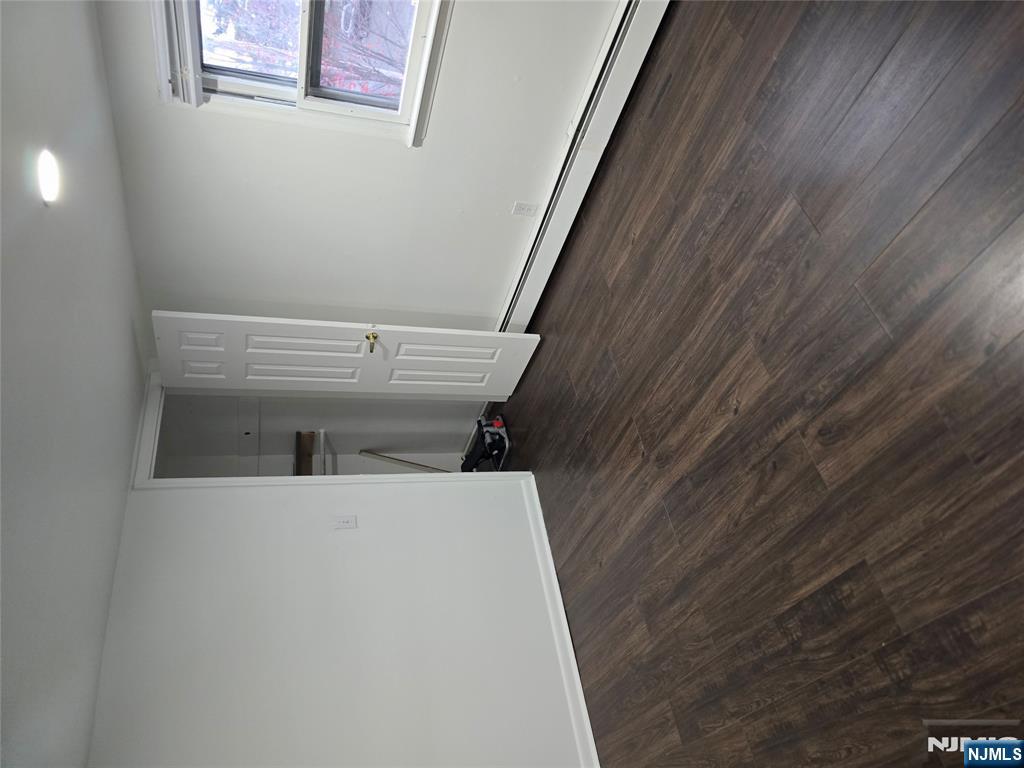 18 Donna Drive, Unit 2 Wood-Ridge, NJ 07075 - Photo 4 of 15 a view of an empty room with wooden floor and a window