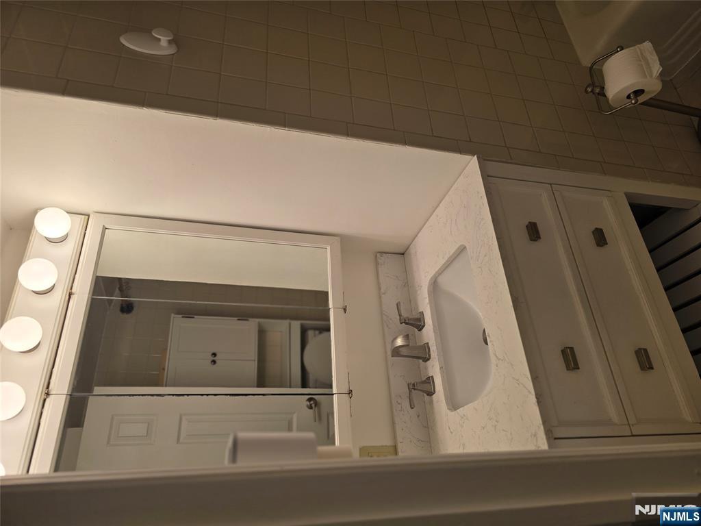 18 Donna Drive, Unit 2 Wood-Ridge, NJ 07075 - Photo 5 of 15 a bathroom with a sink and a mirror