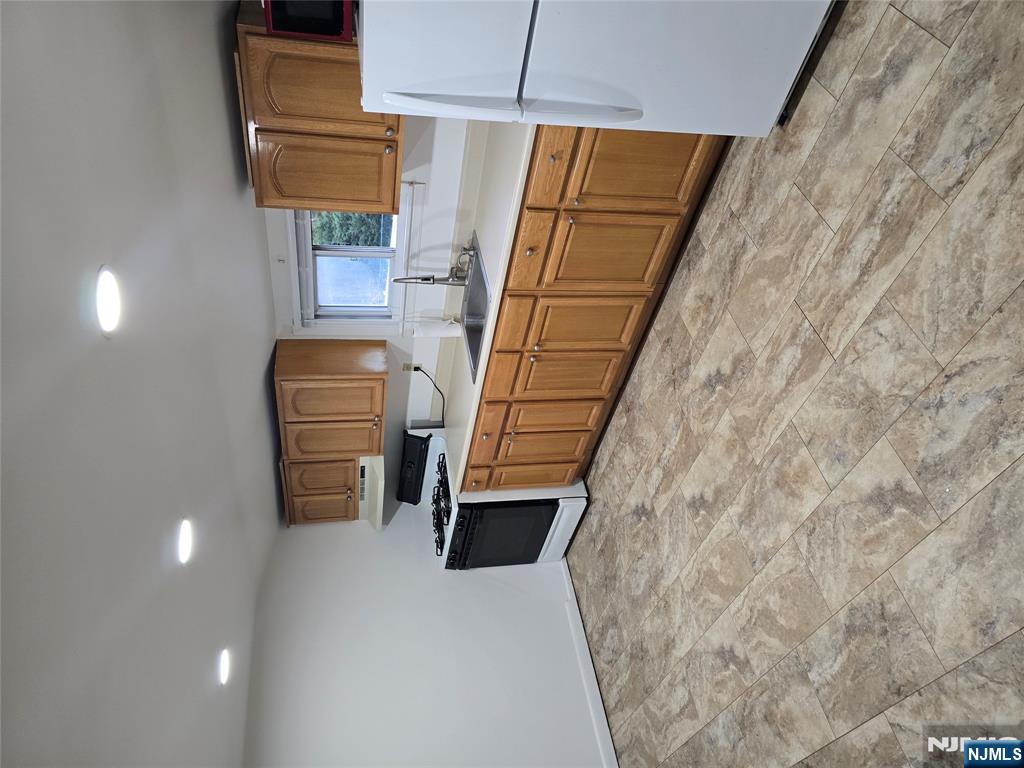 18 Donna Drive, Unit 2 Wood-Ridge, NJ 07075 - Photo 9 of 15 a kitchen with stainless steel appliances granite countertop a refrigerator sink and cabinets