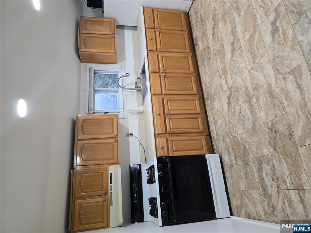 18 Donna Drive, Unit 2 Wood-Ridge, NJ 07075 - Photo 10 of 15 a kitchen with stainless steel appliances granite countertop a stove a sink and a microwave