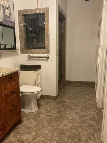 a bathroom with a toilet a sink and mirror