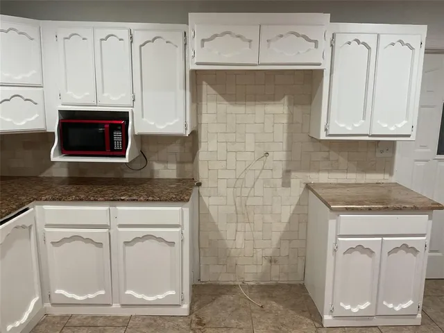 a kitchen with stainless steel appliances granite countertop a stove a microwave and cabinets