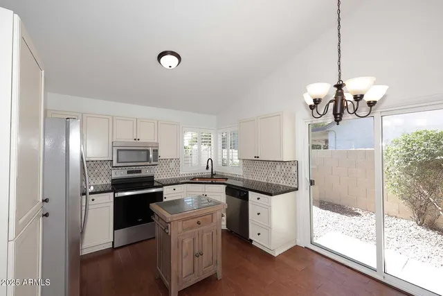 a kitchen with kitchen island granite countertop stainless steel appliances a sink stove and refrigerator