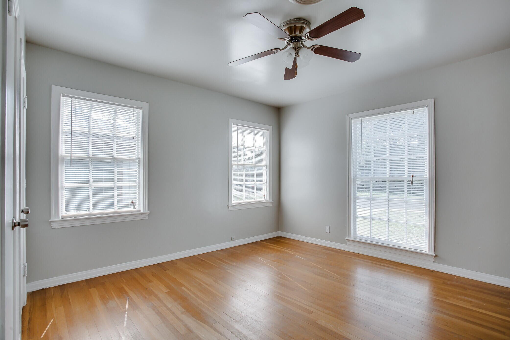 2412 22nd Street Lubbock, TX 79411 - Photo 12 of 18 an empty room with wooden floor fan and windows