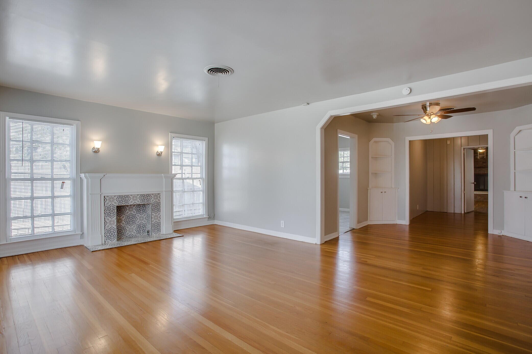 2412 22nd Street Lubbock, TX 79411 - Photo 5 of 18 an empty room with wooden floor fireplace and windows