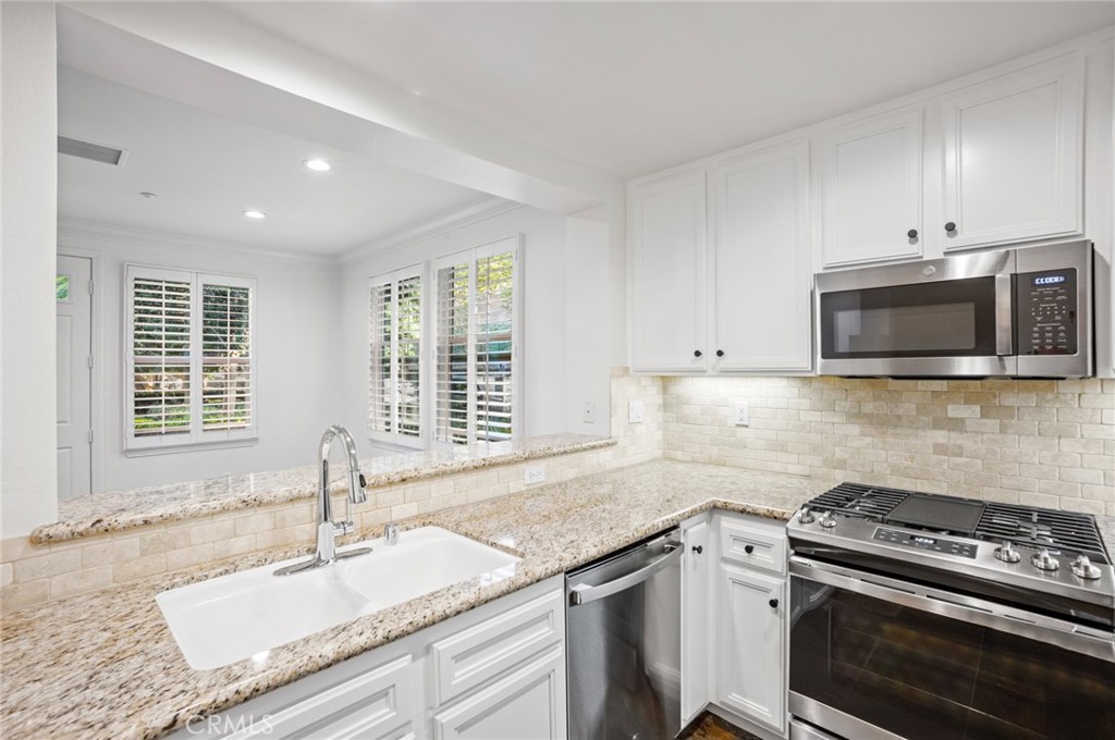 121 Danbrook Irvine, CA 92603 - Photo 6 of 16 a kitchen with granite countertop a sink stove and cabinets