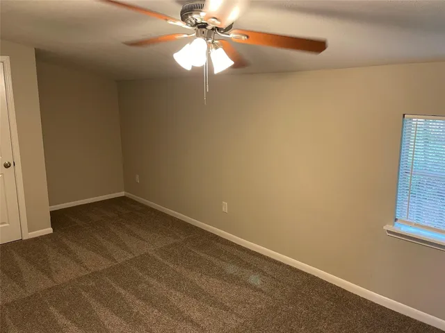 en empty room with windows and fan