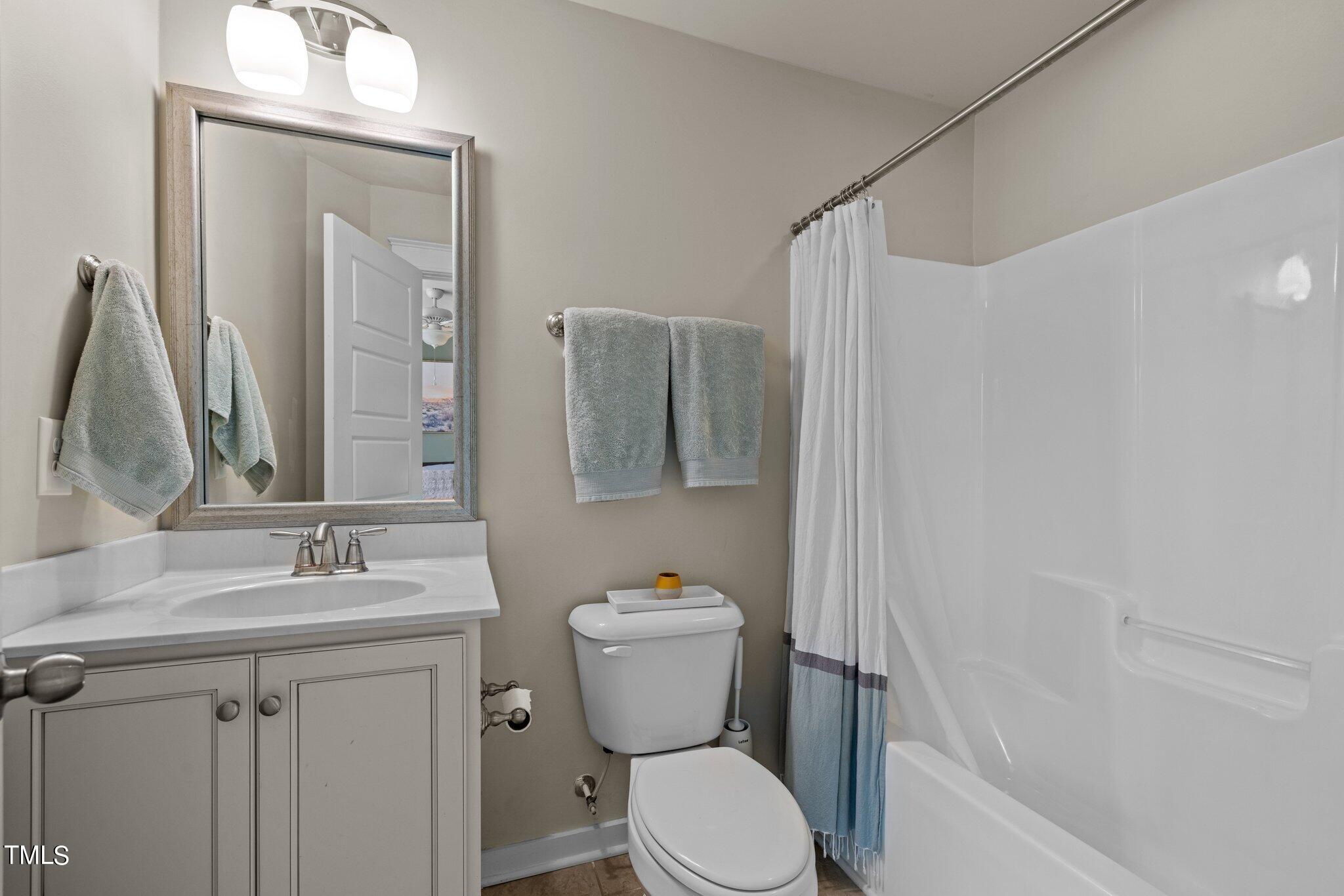 7837 Allscott Way Raleigh, NC 27612 - Photo 14 of 17 a bathroom with a toilet sink and mirror