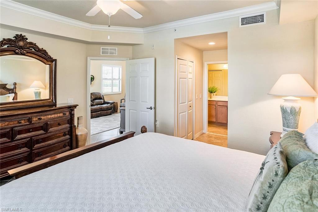 9719 Acqua Court, Unit 228 Naples, FL 34113 - Photo 11 of 35 a bedroom with a bed and a television in it