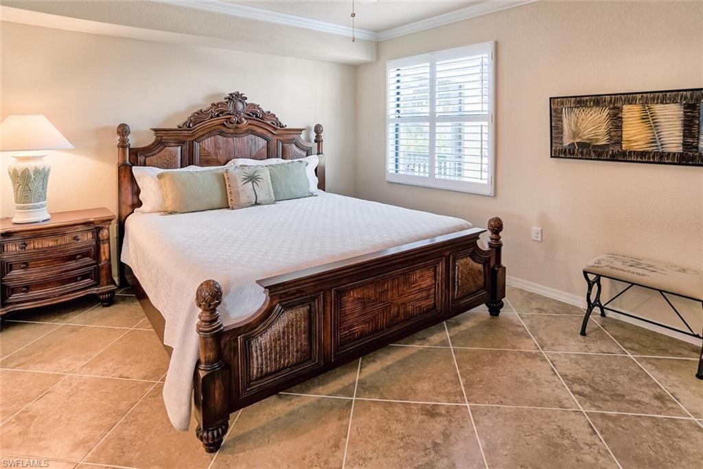 9719 Acqua Court, Unit 228 Naples, FL 34113 - Photo 10 of 35 a bed sitting in a bedroom next to a window