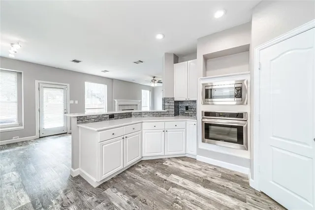 a kitchen with granite countertop white cabinets and stainless steel appliances