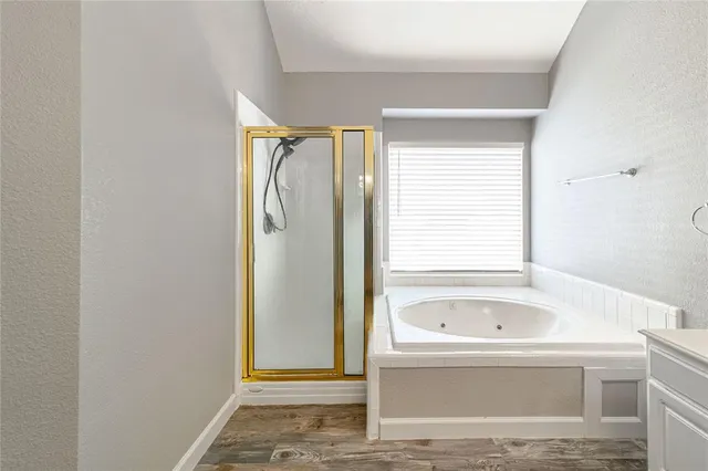 a bathroom with a tub shower and sink